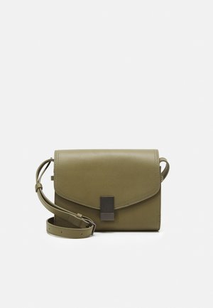 Zielono-oliwkowa skórzana torba crossbody z klapą, regulowanym paskiem i metalicznym prostokątnym akcentem z przodu. Gładka struktura.