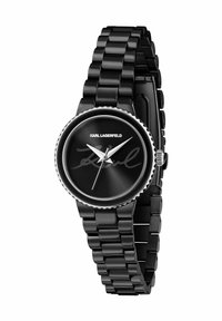 Zwarte horloge met een glanzende metalen band. Rond wijzerplaat heeft een zwarte wijzerplaat met zilveren wijzers en de handtekening van Karl Lagerfeld. Getextureerde lunetteaccenten.