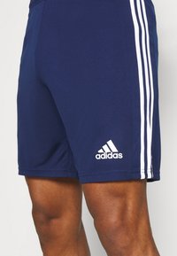 Navy athletic shorts made of smooth, moisture-wicking material. Features three white stripes and an Adidas logo on the lower left leg.