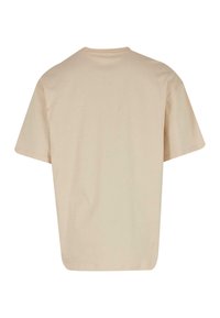 Beige bomulds T-shirt med en afslappet pasform, korte ærmer og en rund halsudskæring. Glat tekstur med et ensfarvet design, ingen synlige logoer eller mønstre.