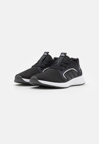 Zapatillas deportivas negras con parte superior de malla, suela blanca y tres rayas negras en el lateral. Presentan cordones y un cuello acolchado.