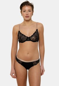Soutien-gorge en dentelle noire avec des motifs floraux, bonnets transparents et bretelles beige clair. Culottes bikini assorties en dentelle noire et bandeau beige.