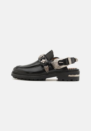 Mustavartoiset nahka slingback-kengät, joissa on hopeiset yksityiskohdat, pyöreä varvaskärki ja teksturoitu pohja, sekä koriste-elementtejä remmeissä.