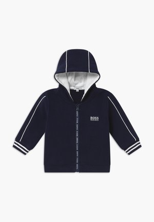 Granatowa bluza z kapturem dla malucha, z białą podszewką, białym obszyciem na rękawach i kapturze, paskowanymi mankietami, pełnym przednim zamkiem oraz logo "BOSS HUGO BOSS" na piersi.