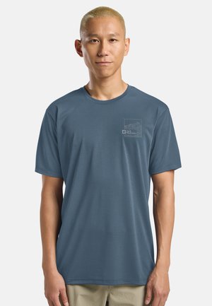 Heren T-shirt met korte mouwen in blauwe stof. Ronde halslijn, zachte textuur, met een subtiele bergafbeelding op de linkerborst.