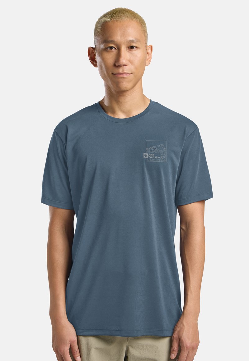 Maglietta a maniche corte da uomo in tessuto blu. Collo rotondo, morbido al tatto, con una sottile grafica di montagne sul petto sinistro.