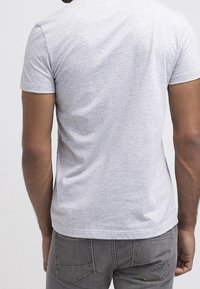 Gray cotton t-shirt with a crew neck, short sleeves, and a fitted design. Smooth texture with minimal detailing on the back.