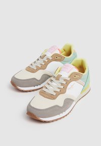 Sneakers wykonane z mieszanki materiałów: beżowa tkanina, brązowy zamsz i szare akcenty. Kolory obejmują żółty, miętowy i pastelowy róż.