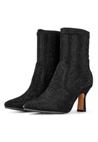 Botines negros con tejido texturizado, adornos brillantes intrincados, punta afilada y un tacón de aguja de 7 cm.