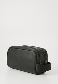 Black leather toiletry bag with two zippers, rectangular shape, textured surface, and branded fabric handle for easy carrying.