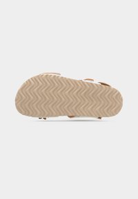 Σόλα σανδάλου με κυματιστό σχέδιο πέλματος, ανοιχτό καφέ χρώμα, εμφανίζεται από κάτω σε λευκό απλό φόντο.