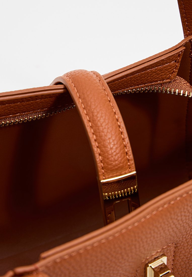 Bruine leren handtas met een gestructureerde afwerking, met gouden hardware, een ritssluiting en een enkele leren handvat. Binnenkant is glad.