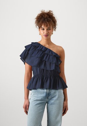 Top na jedno rameno v námorníckej modrej farbe s vrstvenými volánmi, priliehavým pásom a peplum lemom. Vyrobený z ľahkej látky s hladkou textúrou.