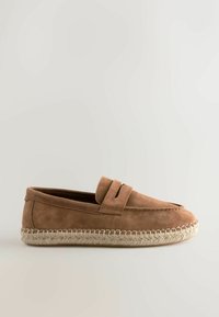 Mocassin en daim marron avec semelle espadrille tissée, détails surpiqués et bride à pièce sur le dessus, présenté de profil sur fond uni.