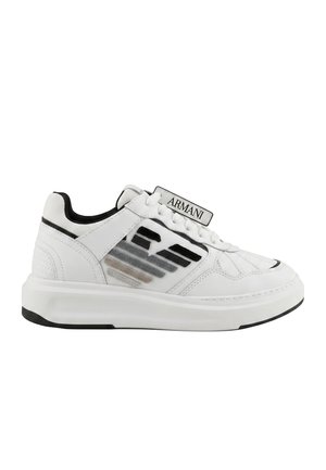 Sneaker bianca bassa con design a strisce nere e grigie, chiusura frontale con lacci, collo imbottito ed etichetta "Armani" sulla linguetta, bordo suola nero.
