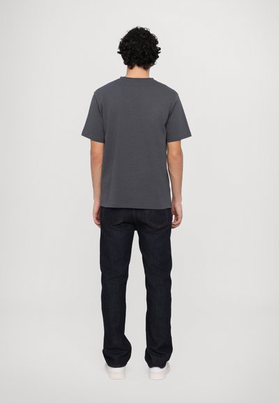 Dark gray short-sleeve t-shirt with a round neckline, paired with dark denim jeans. Plain design, no visible patterns or logos.