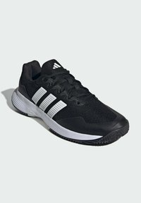 Czarny but sportowy z fakturowaną tkaniną na cholewce, trzema białymi paskami po bokach oraz gumową podeszwą zapewniającą przyczepność.