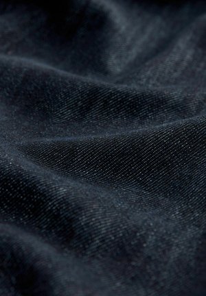 Dark denim fabric with a subtle texture, featuring a smooth surface and slight sheen, displaying folded and draped patterns.
