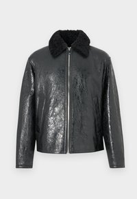 Jaqueta de imitação de couro preta com um acabamento brilhante e texturizado. Apresenta um colarinho de pele de carneiro preta e fecho frontal com zíper. Inclui dois bolsos laterais.