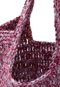 Vävd väska i rosa och grått material, med en strukturerad virkad design, hållbara handtag och ett öppet, rymligt innandöme.