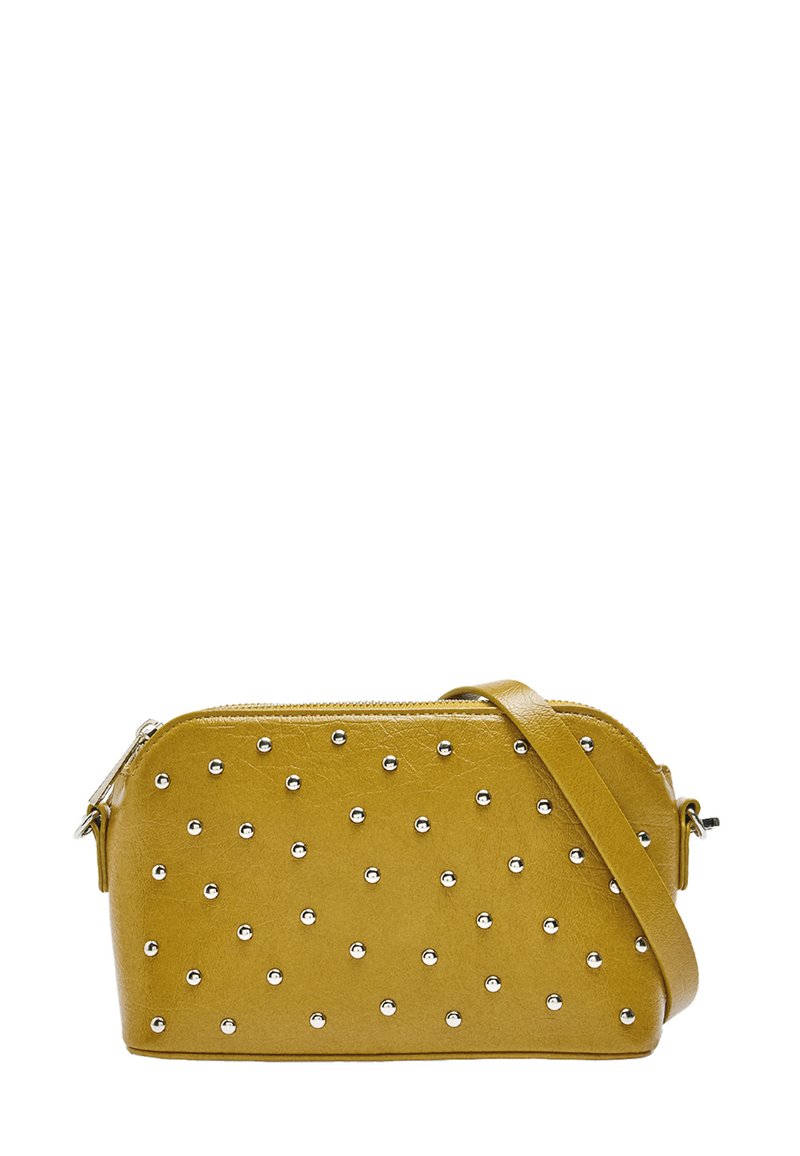 Żółta torebka z ekoskóry z srebrnymi ćwiekami, zamknięcie na zamek błyskawiczny oraz odpinany pasek na ramię. Posiada zaokrąglone krawędzie i płaską podstawę.