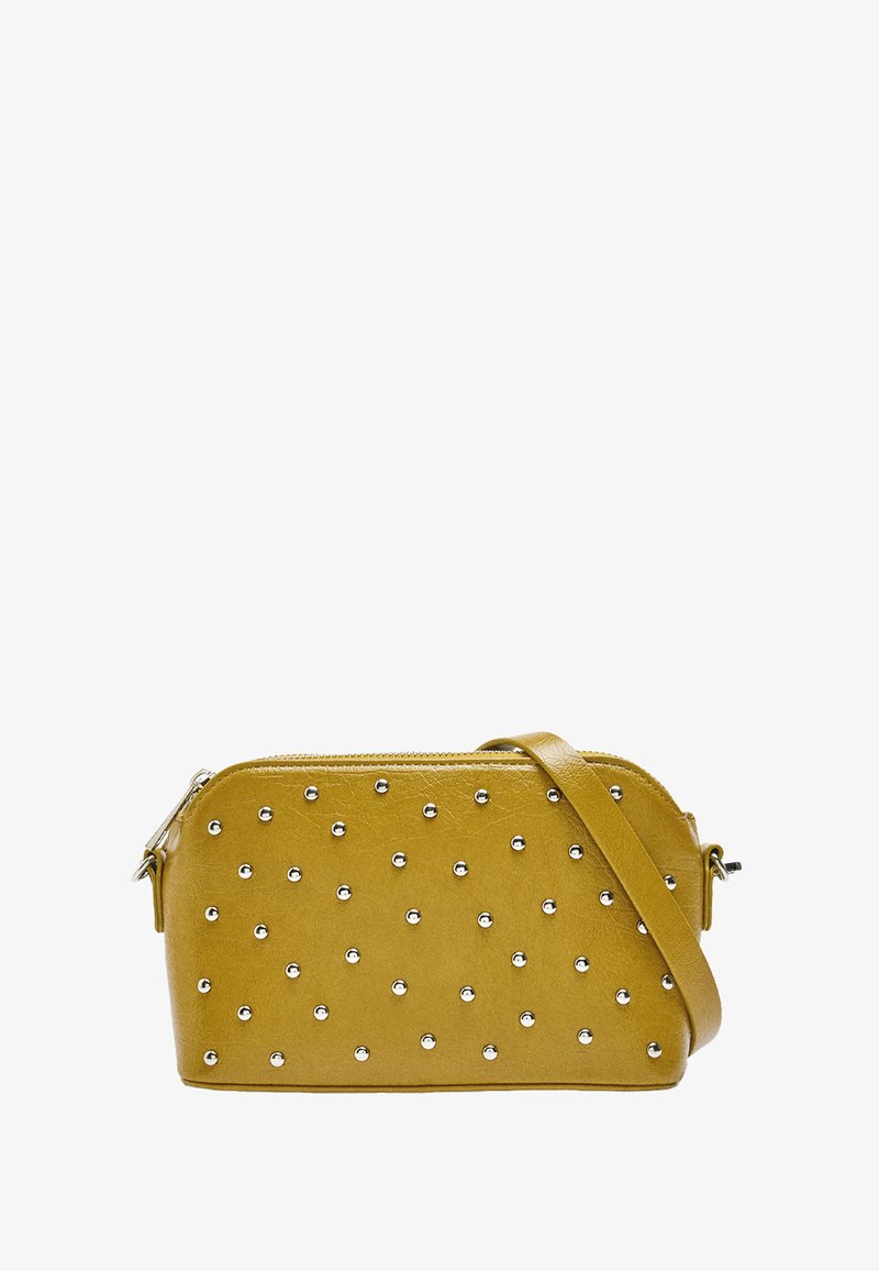 Żółta torebka z ekoskóry z srebrnymi ćwiekami, zamknięcie na zamek błyskawiczny oraz odpinany pasek na ramię. Posiada zaokrąglone krawędzie i płaską podstawę.