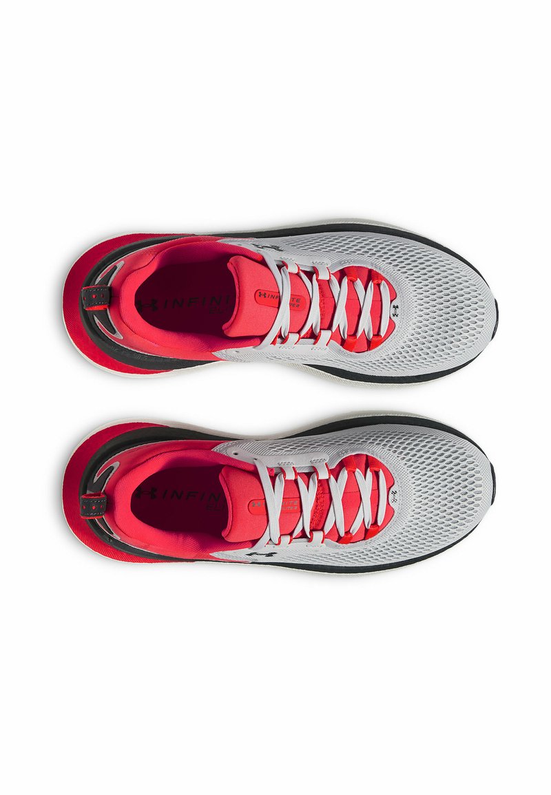 Zapatillas deportivas blancas con detalles rojos, parte superior de malla suave, cordones blancos y suela negra. Presentan acolchado y marcaje en la plantilla.