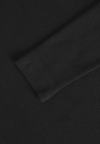 Tissu noir à côtes montrant une section de manches longues avec une texture et des détails de couture visibles. Aucun motif ou accent supplémentaire présent.
