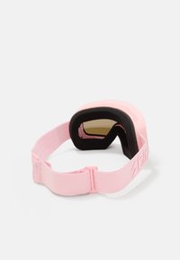 Gafas de esquí rosas con un interior de espuma negra acolchada y correa elástica ajustable sobre un fondo blanco.