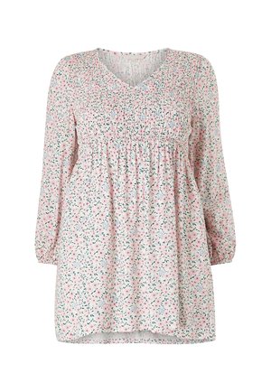 Bloemen tuniek van lichtroze stof met een geraffineerde taille en lange mouwen. Kleine groene en roze bloemen creëren een overal patroon.