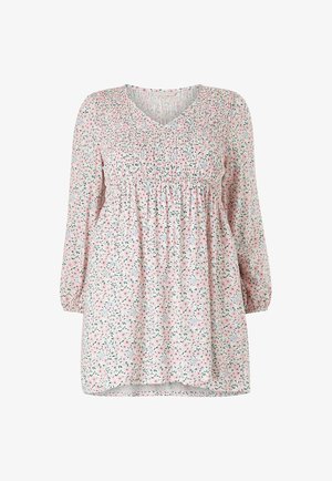 Bloemen tuniek van lichtroze stof met een geraffineerde taille en lange mouwen. Kleine groene en roze bloemen creëren een overal patroon.