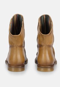 Bottines en cuir marron avec des côtés texturés, offrant une doublure intérieure rayée et une fermeture éclair. Fini lisse et semelle robuste remarquables.