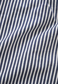 Tissu à rayures verticales bleues et blanches avec plis visibles et texture douce.