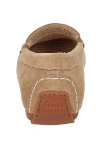 Beige Wildlederschuh mit runder Form, kontrastierenden weißen Nähten und einer tanfarbenen Gummisohle mit Logo-Details an der Ferse.
