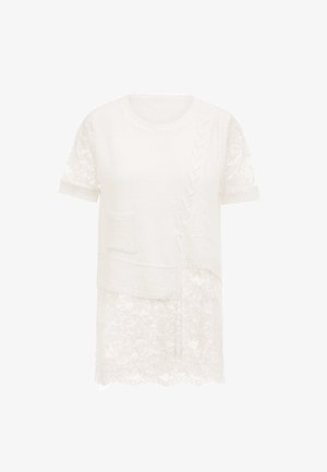 Hvid top med et strikket øverste lag med kabeldesign, korte blondeærmer og en blondebund. Inkluderer en lille brystlomme.