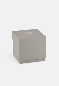 Boîte cadeau grise et texturée en forme carrée, avec un logo triangulaire doré sur le dessus et une base lisse.