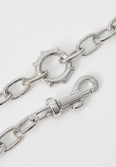 Silver metal chain with linked oval and circular shapes; features a decorative clasp with textured accents. Smooth, shiny finish.