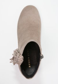 Bota ankle de ante topo con punta redondeada, detalle decorativo de borlas en el lateral y cierre de cremallera. Interior forrado con tela negra.