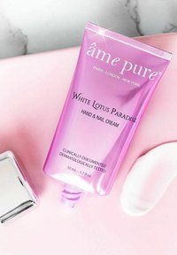 Hand- und Nagelcremetube in glänzender pinkfarbener Verpackung, beschriftet mit "Weißer Lotusparadies", 50 ml, mit silbernem Akzent und glatter Textur.