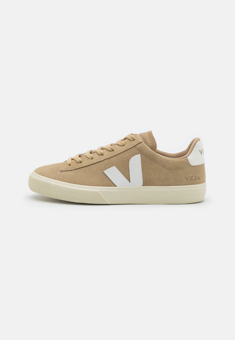 Tan suede sneakers with white logo accents and perforation details. Low-top design with round toe and textured rubber sole.