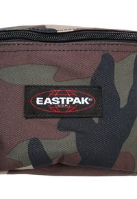 Bolsita de camuflaje hecha de tejido duradero, con una etiqueta de logo negro de Eastpak. Incluye un cierre de cremallera en la parte superior.