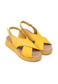 Gelbe Wildledersandalen mit Wedge-Absatz. Mit überkreuzten Riemen und einem Knöchelverschluss. Weiche Innenauskleidung, glatte Außensohle.