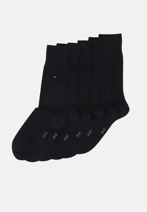 Meias de algodão pretas, com um design canelado e um logótipo discreto, apresentando uma textura suave. O pacote inclui várias pares para uso diário.