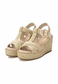 Sandali wedge intrecciati beige con tomaia texturizzata, design open toe e cinturino alla caviglia regolabile con un accento a fibbia dorata.