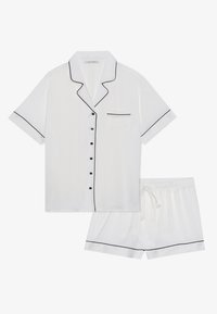 Valkoiset lyhythihaiset pyjamasetit, jotka on valmistettu sileästä kankaasta. Niissä on mustat reunat, tasku ja mustat napit paidassa. Shortseissa on joustava vyötärö.
