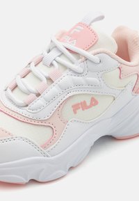 Hvit sneaker med rosa detaljer, med en teksturert mesh-overdel, polstret krage, særegen Fila-logo og snøring.