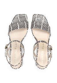 Sandalias de punta cuadrada en cuero con estampado de serpiente en blanco y negro, con una correa en el tobillo y hebilla ajustable, y plantilla beige.