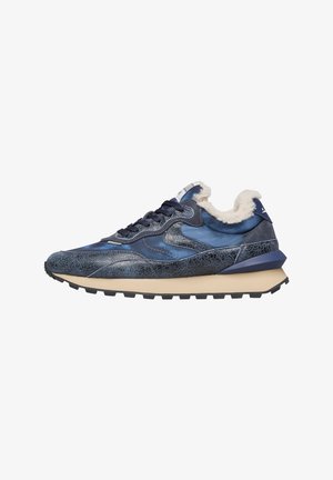 Blauwe sneaker met gebarsten textuur, beige zool, zwarte veters en witte fluffy voering op de kraag tegen een witte achtergrond.