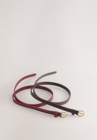 Due cinture sottili in pelle color bordeaux e marrone scuro con fibbie dorate, caratterizzate da texture lisce e fori multipli per la regolazione della taglia.