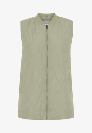 Lys olivengrønn uten ermer quiltet vest med glidelås foran, ribbestrikket krage og sidelommer, med et bølgemønster på stoffet.